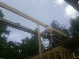 Carpenter setting a ridge beam over a new addition frame — Ice Dam Removal by Roofing Brothers in South Kent