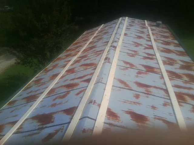 Rusted metal roof panels with new wood purlins before replacement — Storm Damage Roof Repair in South Kent by Roofing Brothers