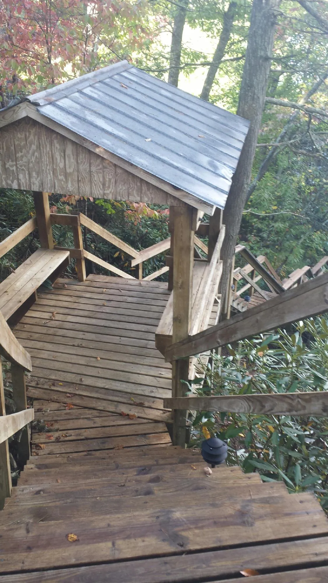 Metal roofed shelter over wooden steps on a wooded walkway — Skylight Repair & Installation work by our crew in South Kent